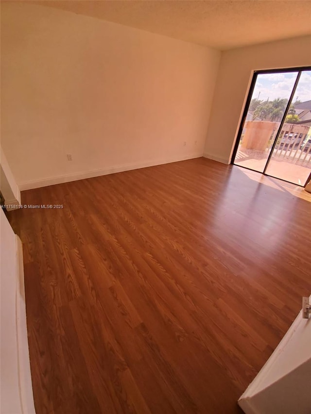 empty room featuring baseboards and wood finished floors