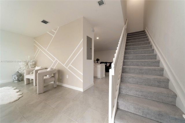 stairway featuring baseboards, recessed lighting, visible vents, and tile patterned floors