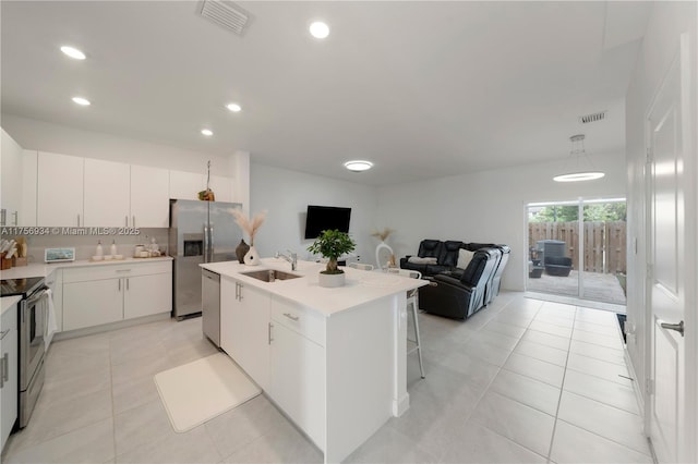 kitchen featuring light tile patterned floors, visible vents, appliances with stainless steel finishes, and a sink