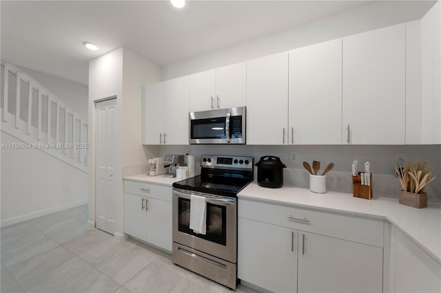 kitchen featuring stainless steel appliances, recessed lighting, light countertops, and white cabinets