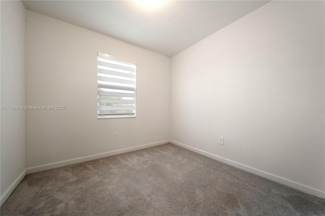 spare room featuring carpet flooring and baseboards