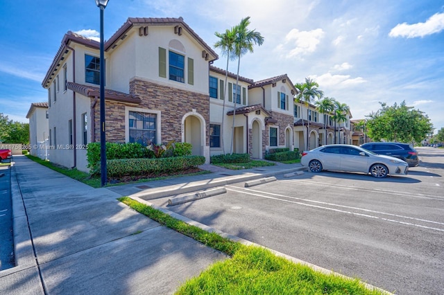 9399 W 33rd Ln # 1, Hialeah, FL 33018 - view of front of house with stucco siding, stone siding, uncovered parking, and a tile roof