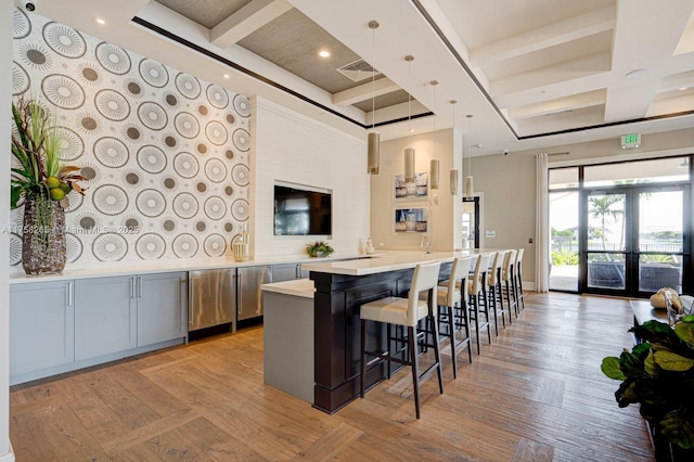 9399 W 33rd Ln # 1, Hialeah, FL 33018 - kitchen featuring visible vents, beamed ceiling, coffered ceiling, a breakfast bar area, and light countertops