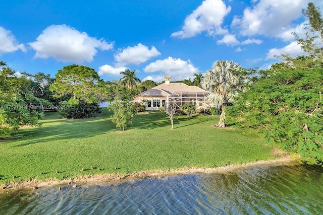 exterior space featuring a lanai, a yard, and a water view