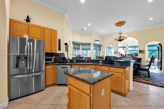 kitchen featuring a kitchen island, light tile patterned floors, appliances with stainless steel finishes, a peninsula, and a sink