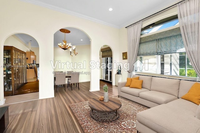 living area with wood finished floors, an inviting chandelier, recessed lighting, arched walkways, and crown molding