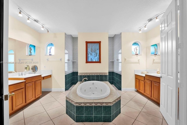 bathroom featuring tile patterned floors, a wealth of natural light, two vanities, and a whirlpool tub