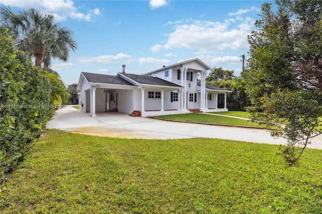 rear view of property with a yard, driveway, and stucco siding