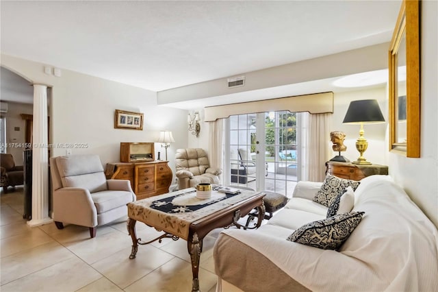 living area featuring french doors, visible vents, decorative columns, and light tile patterned floors