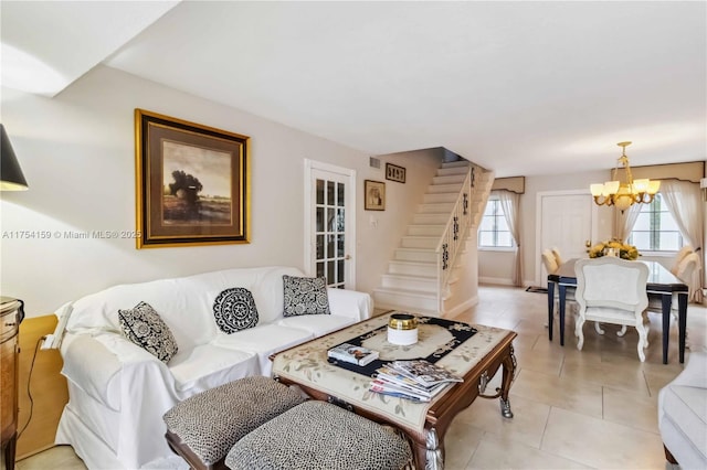 living room with light tile patterned floors, stairway, baseboards, and an inviting chandelier