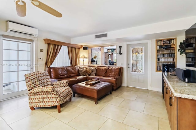 living area with a ceiling fan, an AC wall unit, visible vents, and light tile patterned flooring