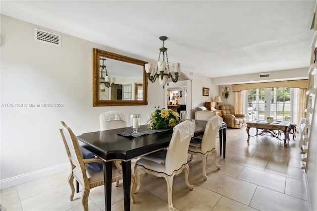 dining room featuring a chandelier, light tile patterned flooring, visible vents, and baseboards