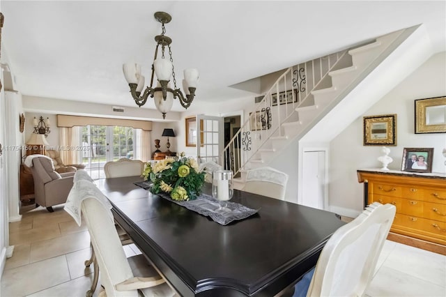 dining space featuring french doors, light tile patterned floors, a notable chandelier, and stairs