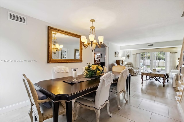 dining room with baseboards, light tile patterned flooring, visible vents, and a notable chandelier