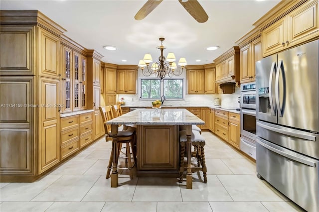 kitchen with light tile patterned floors, a breakfast bar, a sink, stainless steel fridge with ice dispenser, and light stone countertops