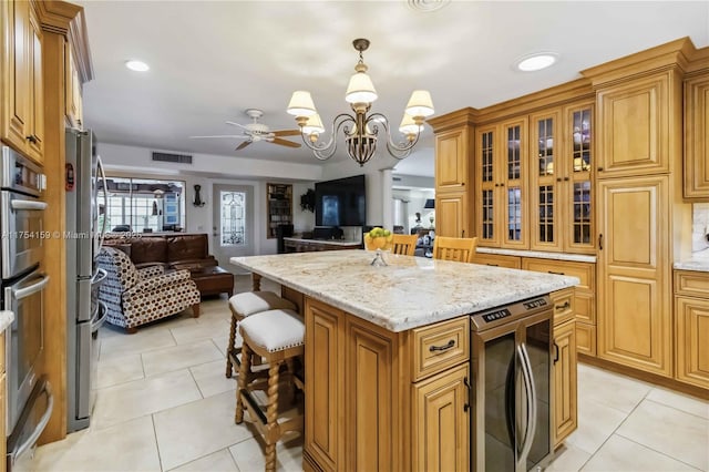 kitchen featuring beverage cooler, visible vents, open floor plan, a center island, and light tile patterned flooring