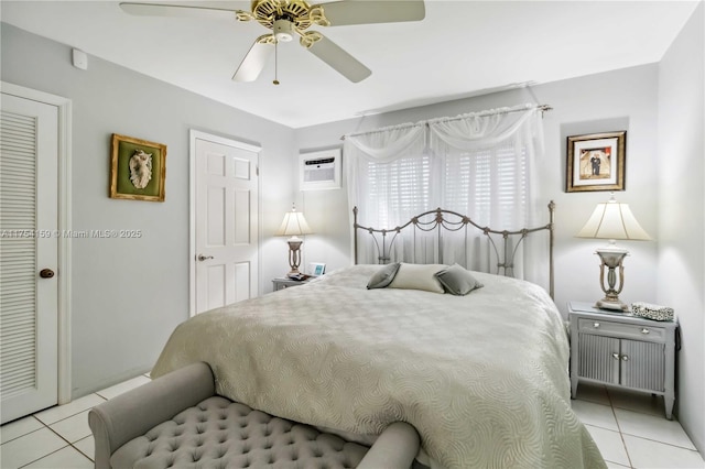 bedroom featuring light tile patterned floors, a ceiling fan, and an AC wall unit