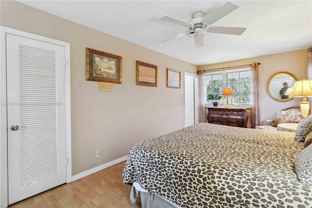 bedroom with light wood-type flooring, baseboards, and a ceiling fan