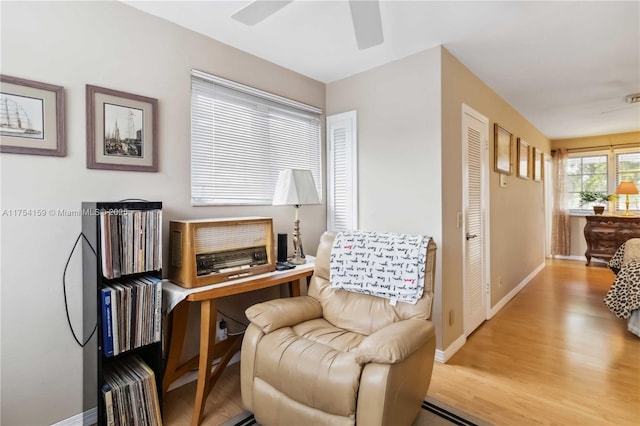 living area with ceiling fan, wood finished floors, and baseboards