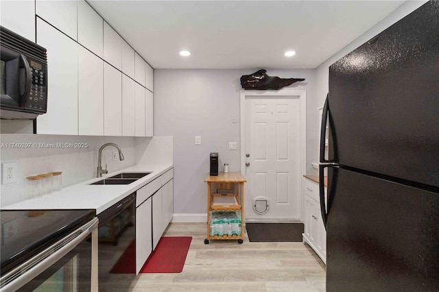 400 S 62nd Ter, Hollywood, FL 33023 - kitchen featuring light wood-style flooring, a sink, white cabinets, light countertops, and black appliances