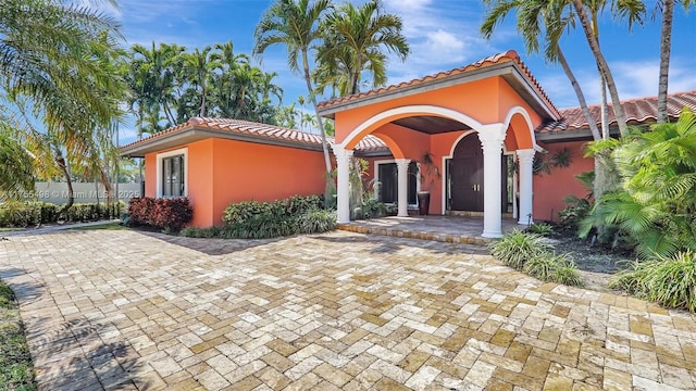 view of front of property featuring a tiled roof and stucco siding