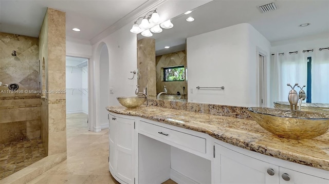 full bath featuring a spacious closet, visible vents, recessed lighting, tiled shower, and vanity