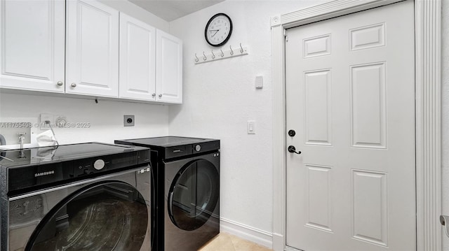 laundry room featuring washing machine and clothes dryer, light tile patterned floors, cabinet space, and baseboards