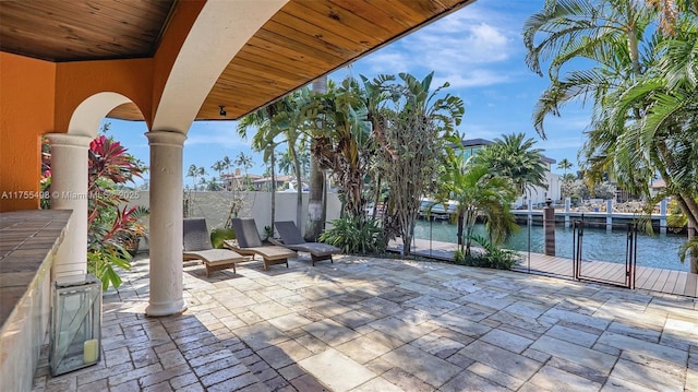 view of patio / terrace with a water view and fence