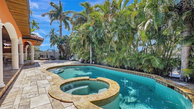 view of pool with a pool with connected hot tub and a patio