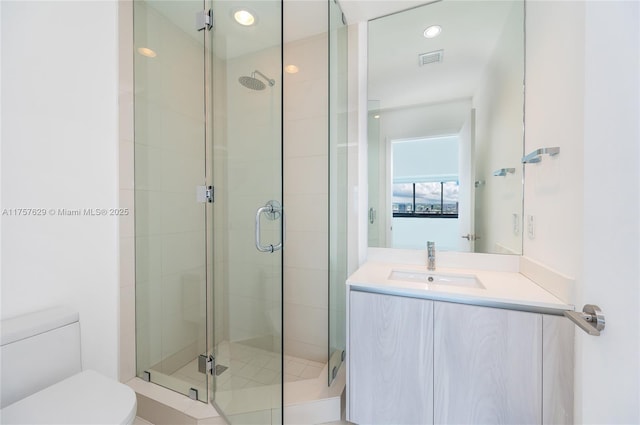 bathroom featuring toilet, recessed lighting, vanity, visible vents, and a shower stall