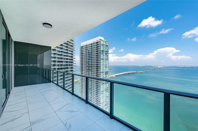 balcony with a water view and a view of city