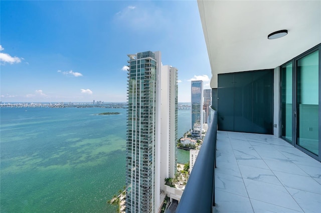 balcony featuring a water view and a city view