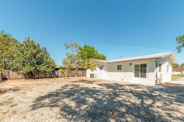 back of house featuring fence and stucco siding