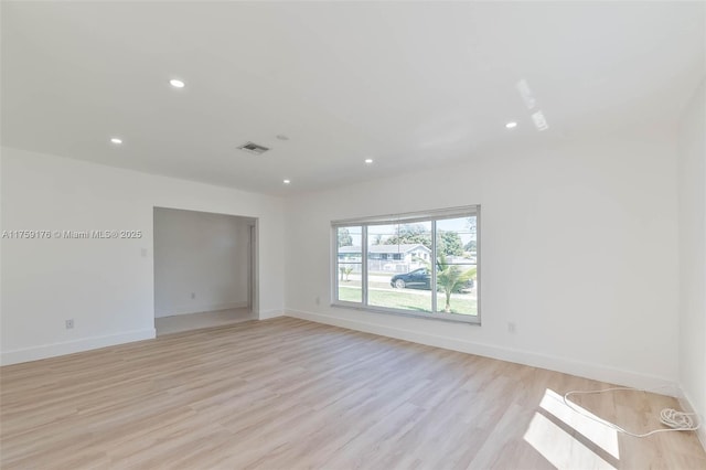 unfurnished room featuring light wood-style flooring, visible vents, baseboards, and recessed lighting