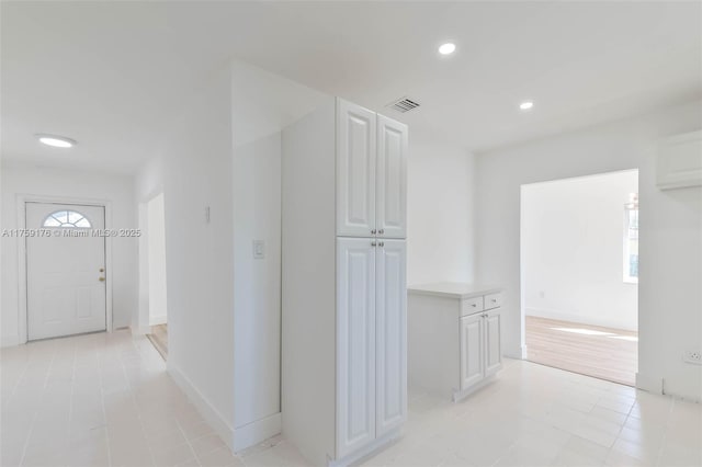 corridor with baseboards, visible vents, and recessed lighting