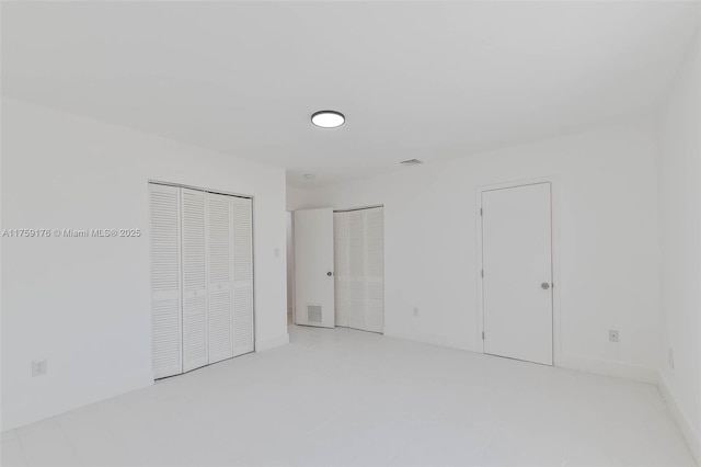 unfurnished bedroom with multiple closets