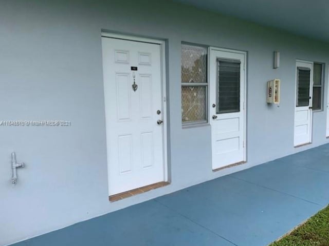 doorway to property featuring stucco siding