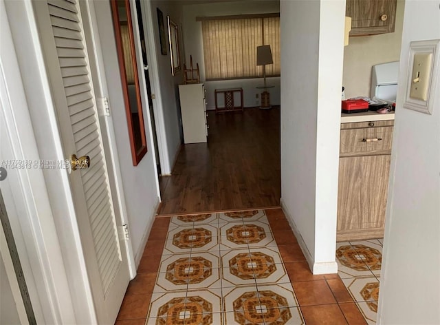 corridor featuring tile patterned flooring and baseboards