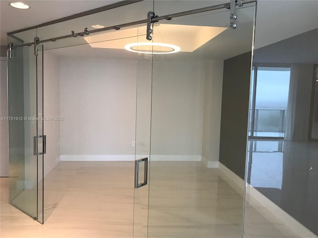 interior space featuring baseboards and a barn door