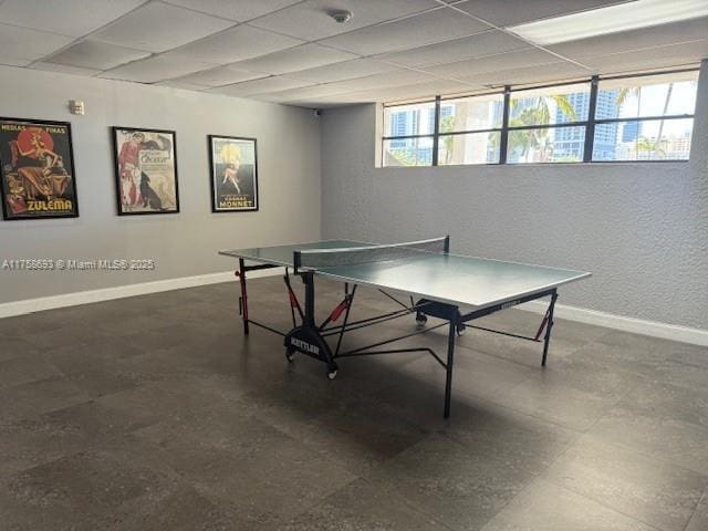 playroom featuring a drop ceiling and baseboards