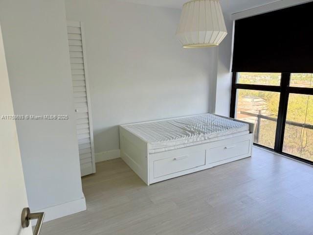 unfurnished bedroom featuring light wood-type flooring and baseboards