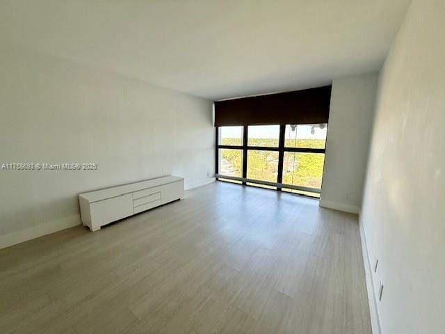 unfurnished room with wood finished floors and baseboards