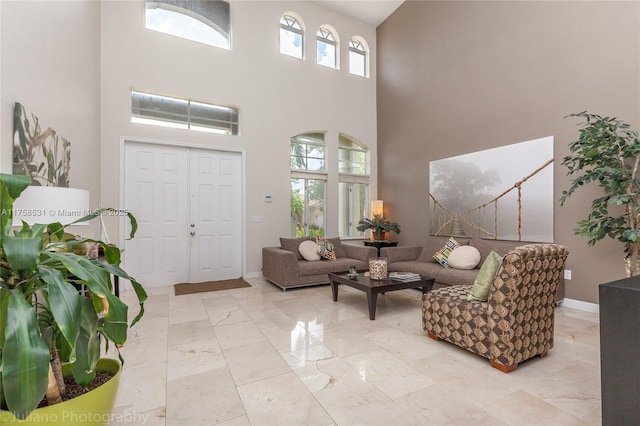 living area featuring marble finish floor, plenty of natural light, and baseboards