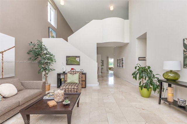 interior space with a high ceiling, a healthy amount of sunlight, and baseboards