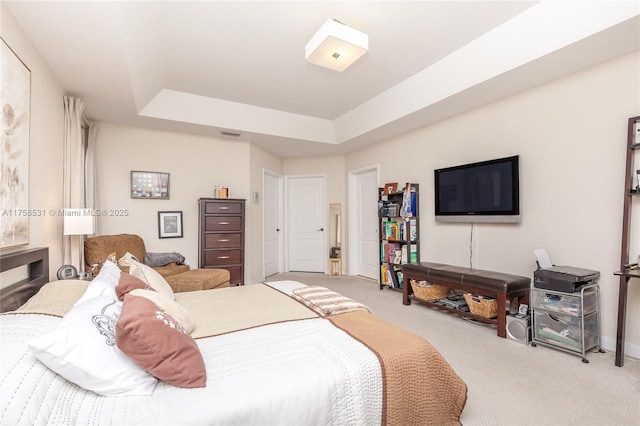 carpeted bedroom with a tray ceiling and visible vents