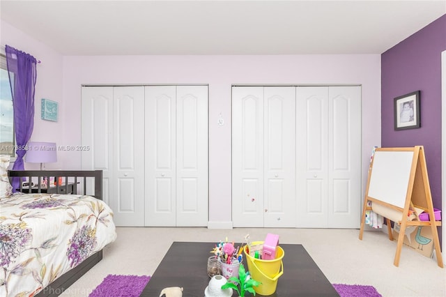 bedroom featuring carpet and multiple closets