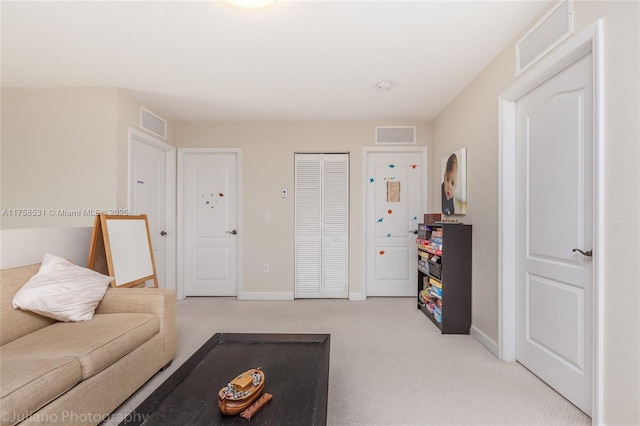 carpeted living area featuring baseboards and visible vents