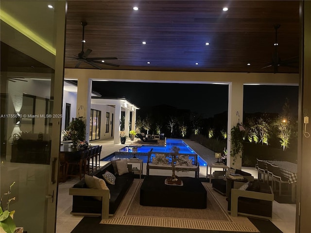 pool at night with a ceiling fan, an outdoor living space, a patio, an outdoor pool, and outdoor dining area