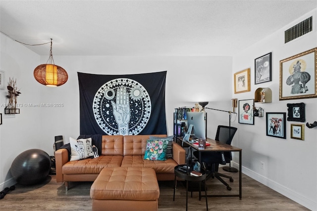 living area featuring wood finished floors, visible vents, and baseboards