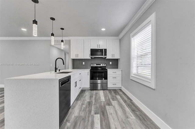 kitchen with a peninsula, a sink, baseboards, appliances with stainless steel finishes, and decorative backsplash